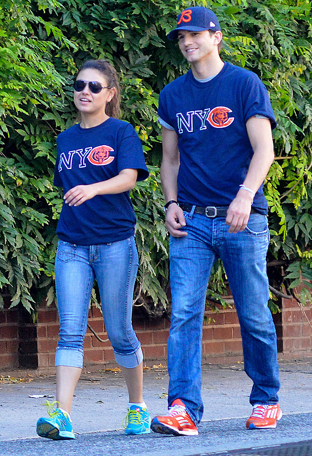 84473, NEW YORK, NEW YORK - Sunday September 23, 2012. Ashton Kutcher and Mila Kunis wear matching Chicago Bears shirts as they go for a walk in the West Village, NYC. The happy couple, showing the love for their favorite football team with their adorable matching outfits, embraced as they waited to cross the street before going out for some Gelato on their romantic stroll. Photograph: &#xA9   ;PacificCoastNews.com