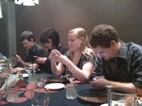 Young diners all using smart phones