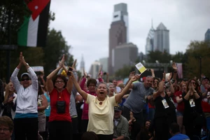 People cheer as they gather along Benjamin Franklin Parkway on Sept. 27, 2015 in Philadelphia. (Photo by Carl Court/Getty Images)